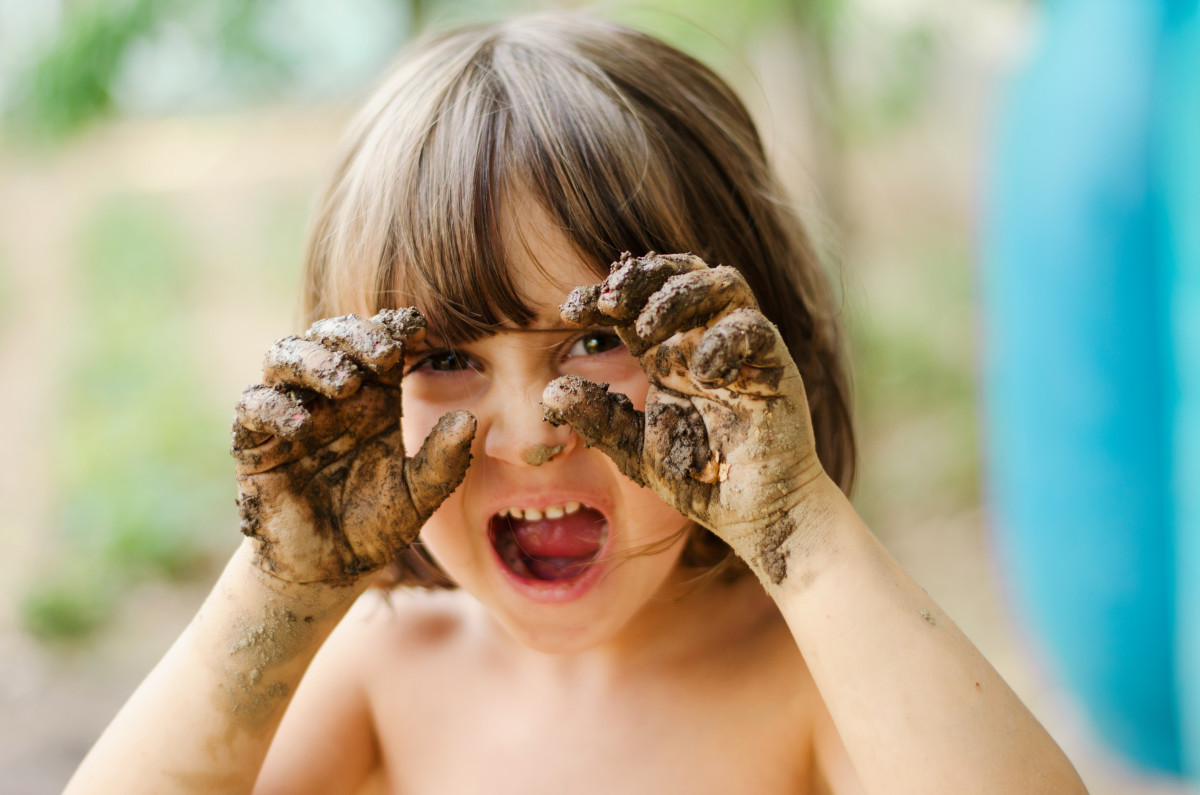 Barn med lera på sina händer