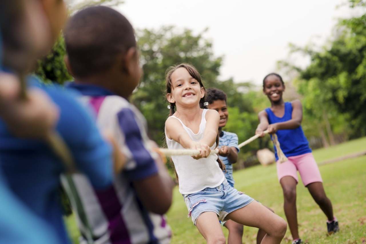 crianças brincando com uma corda no parque